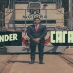 El empresario Augusto Marini junto a una locomotora con el logo de Motora Argentina y los logotipos de los canales de streaming Carajo y Blender.
