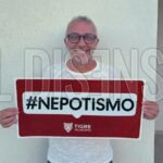 Julio Zamora, intendente de Tigre, posando con un cartel rojo que dice '#NEPOTISMO