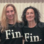 Karina Milei y Mara Gorini juntas, usando una remera negra con la palabra "FIN" estampada en letras blancas.